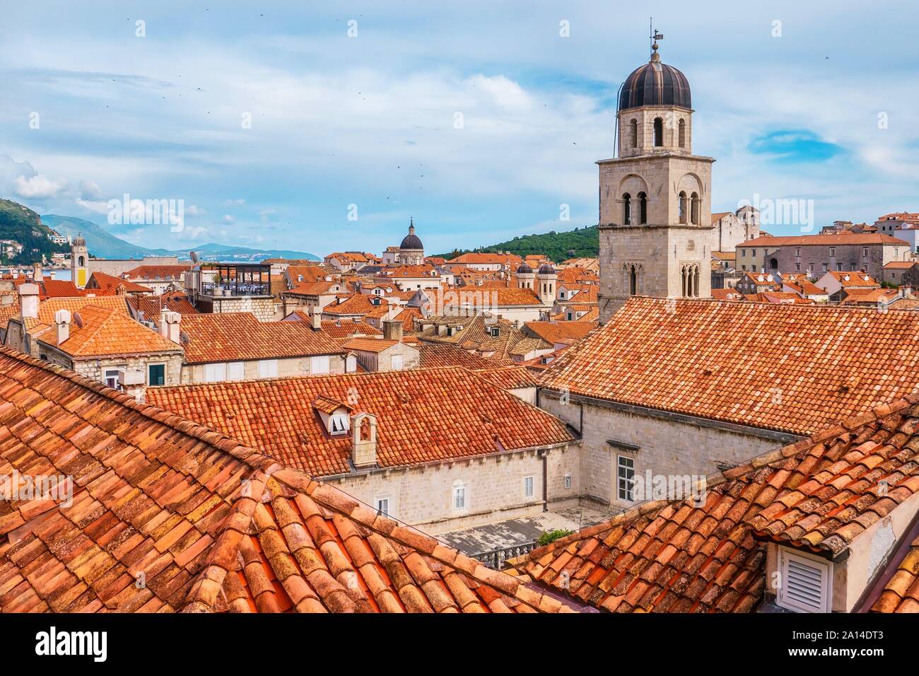Angolo di alta vista delle piastrelle di colore arancione e la costruzione di tetti nella Città Vecchia di Dubrovnik in Croazia, con la parte superiore del suo caratteristico campanile visibile. Foto Stock