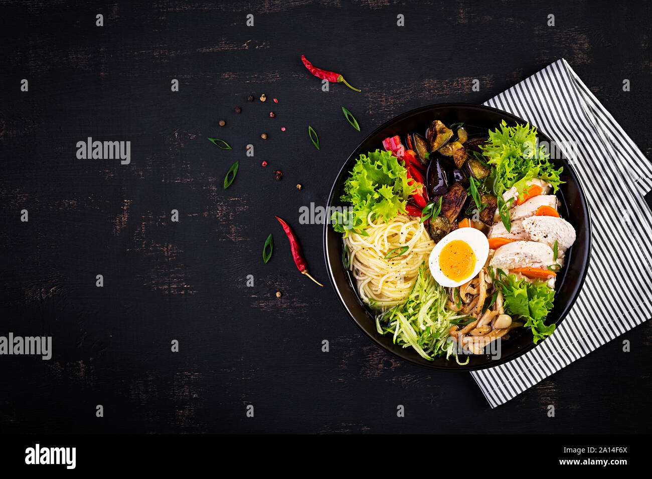 Giapponese ramen zuppa di pollo, uova, funghi shimeji e melanzane su legno scuro dello sfondo. Chanko nabe, zuppa di sumo. Vista superiore Foto Stock