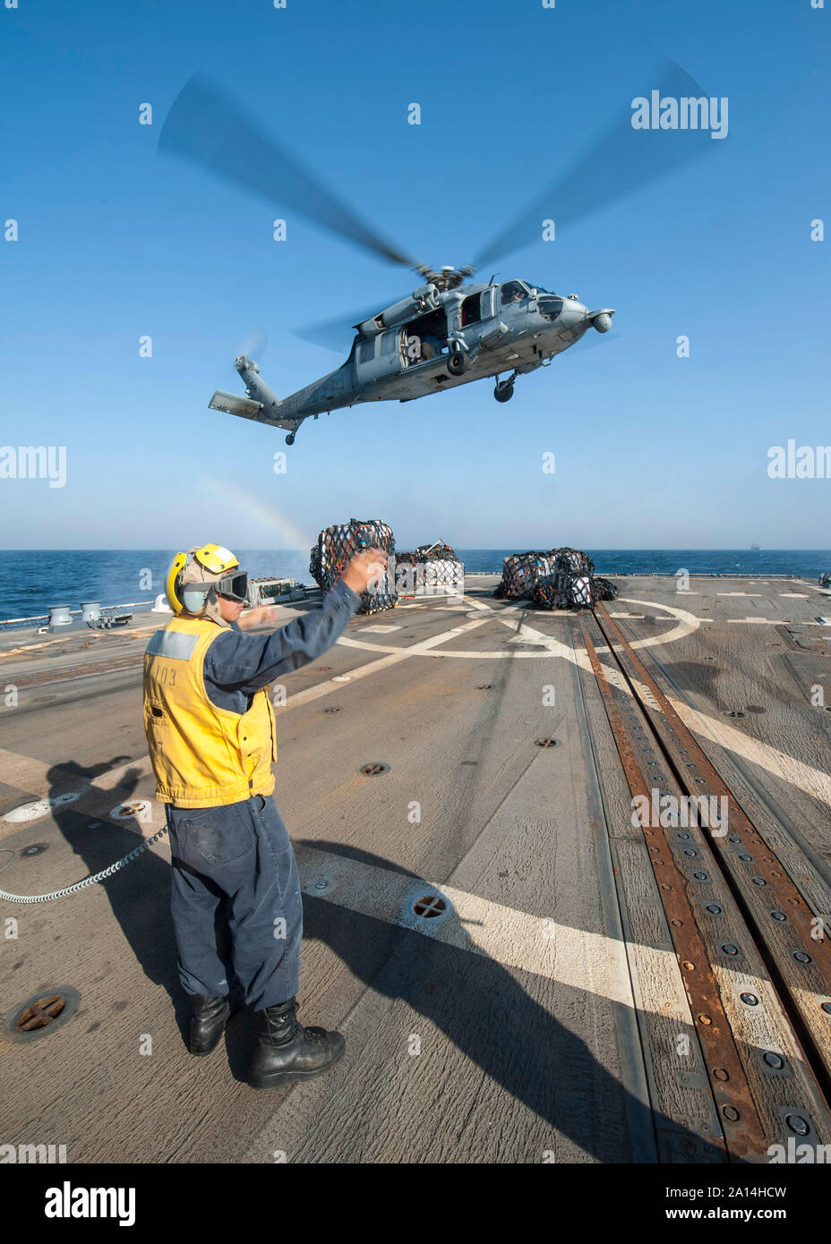 Un MH-60S Seahwak scende alimenta sulla USS Truxton. Foto Stock