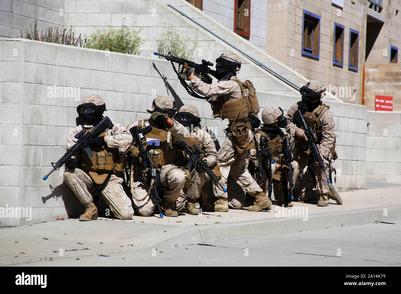 Stati Uniti Marines prendere la copertura dietro un muro durante un corso di formazione per l'evoluzione. Foto Stock