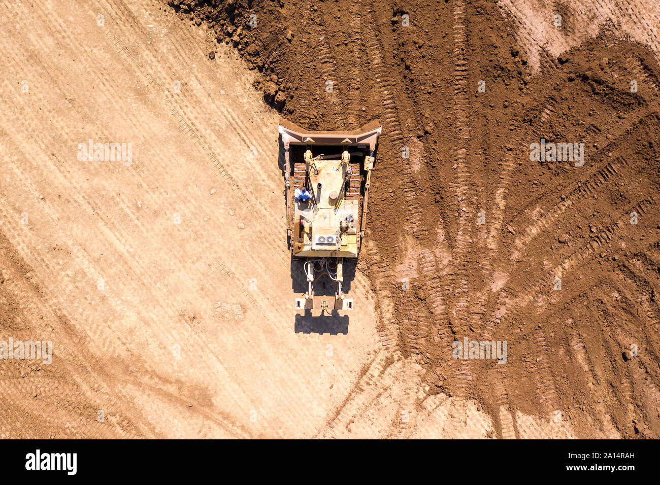 Bulldozer spingendo grandi quantità di terreno fresco, immagine aerea. Foto Stock