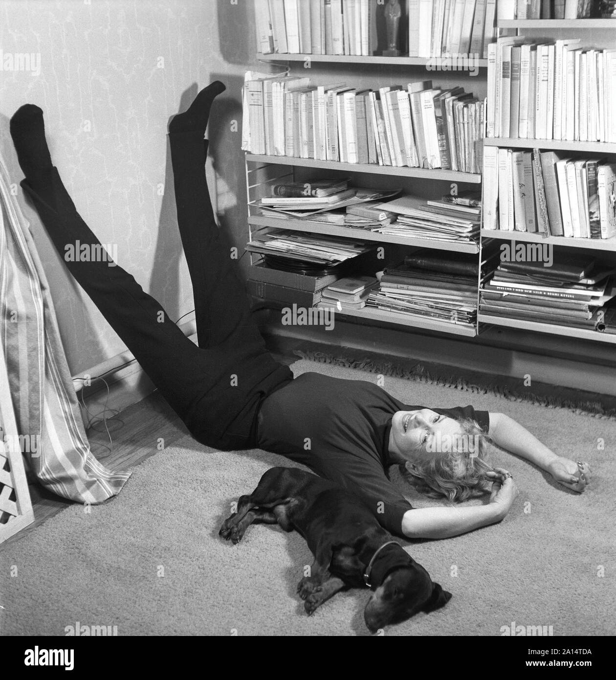 Donna degli anni cinquanta. Una donna e il suo cane sono sdraiato sul pavimento rilassante. Ella è l'attrice Sonja Wigert. La Svezia 1954. Kristoffersson ref BP6-9 Foto Stock