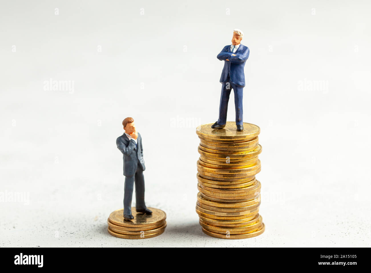 Imprenditore di successo con grandi profitti sulla pila di monete d'oro e meno gli imprenditori di successo con le piccole imprese. Il concetto di come imparare a guadagnare di più attività di apprendimento Foto Stock