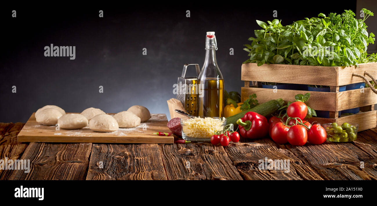 Panorama banner con cibi freschi ingredienti per cucina Italiana compresi i pomodori, il basilico, olio d'oliva, formaggi, peperoni e la porzione di pasta cruda o Foto Stock