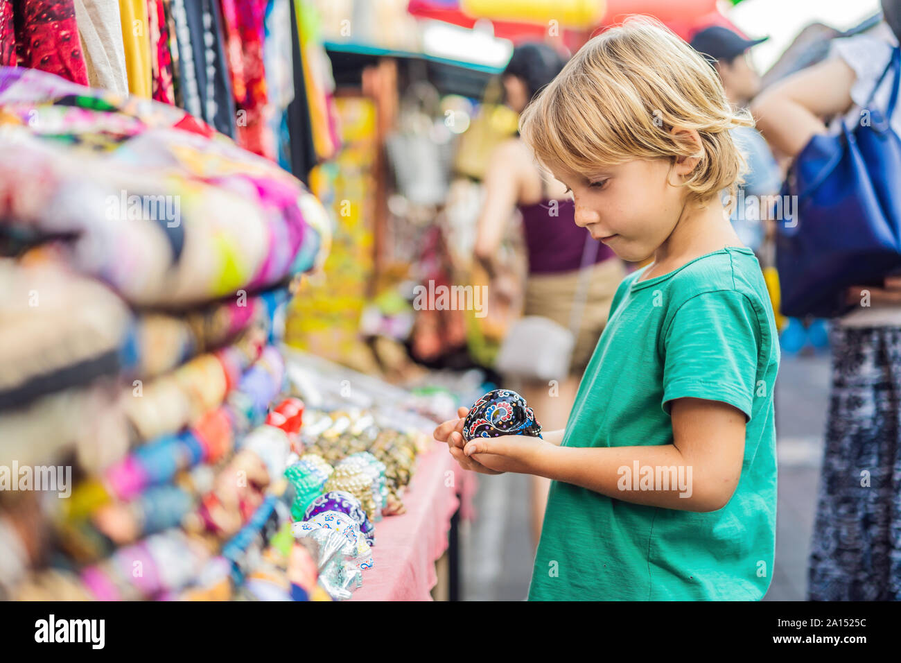 Ragazzo in un mercato in Ubud, Bali. Tipico souvenir shop vende souvenir e artigianato di Bali presso il famoso mercato di Ubud, Indonesia. Mercato Balinese Foto Stock
