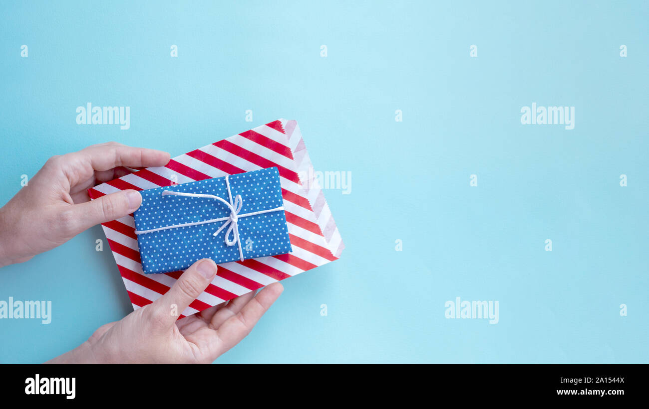 Donna con le mani in mano in maglione azienda confezione regalo. Formato intestazione, copia dello spazio. Foto Stock