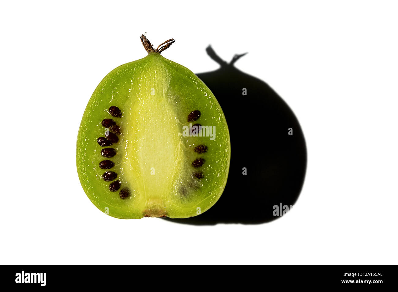 La metà di un kiwi berry con ombra isolati su sfondo bianco Foto Stock