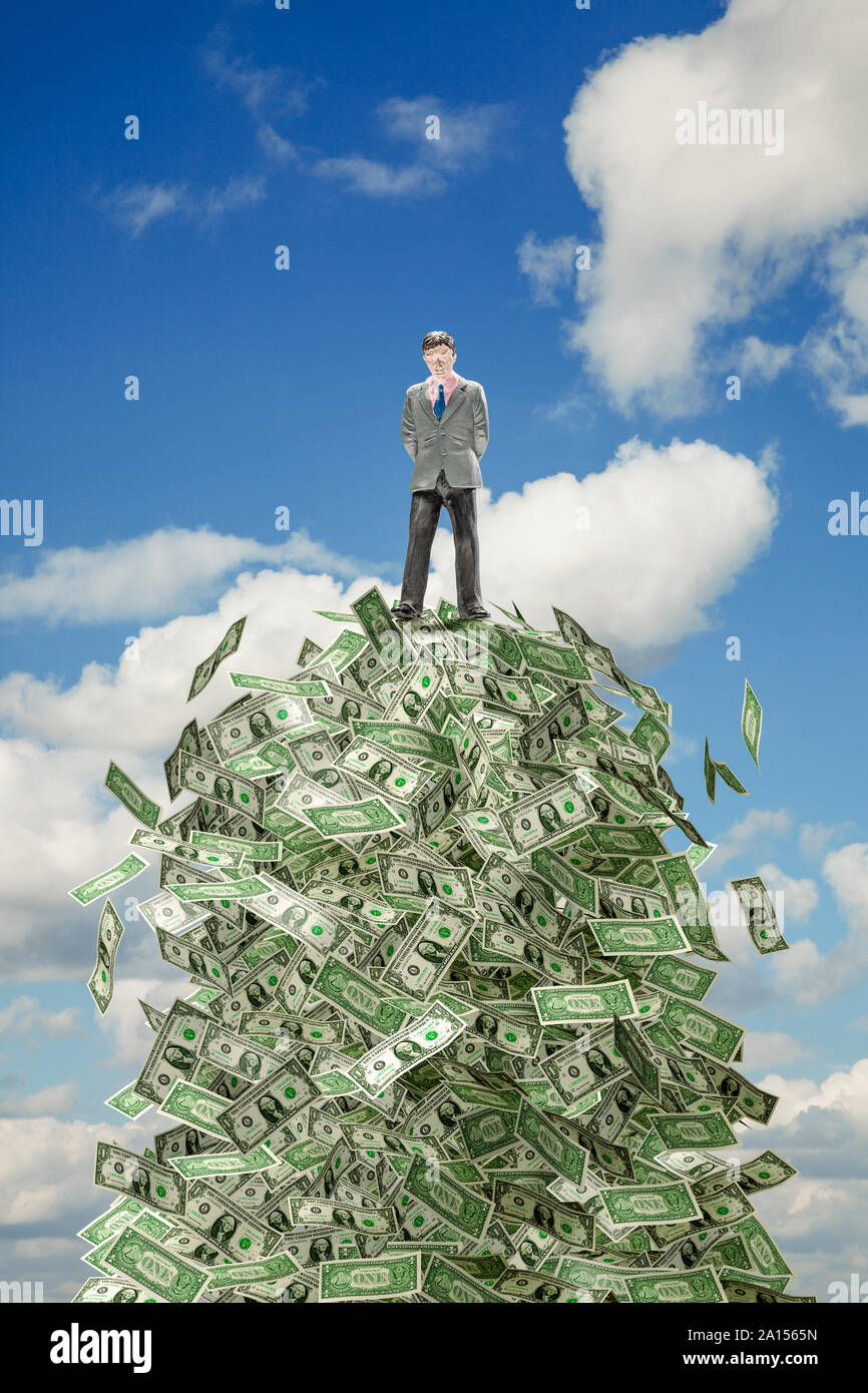 Imprenditore figura in piedi su una pila di fatture del dollaro contro una soleggiata cielo blu di sfondo - Concetto di successo Foto Stock