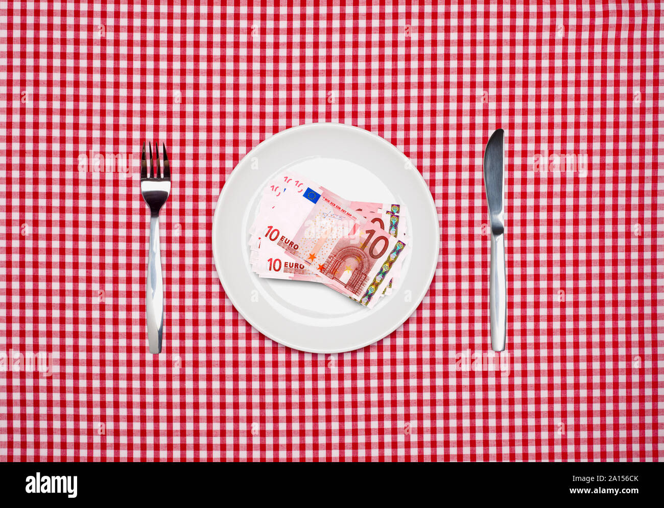 Le banconote in euro su una piastra bianca con coltello e forchetta vista aerea Foto Stock