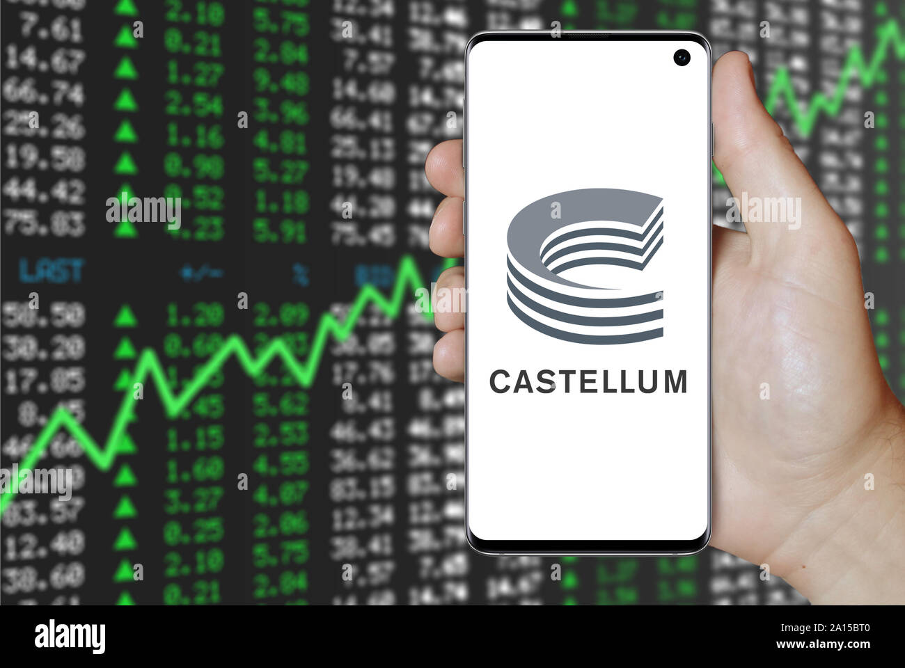 Un uomo possiede uno smartphone visualizzando il logo della società Castellum elencati su OMX di Stoccolma. Positivo del mercato azionario sfondo. Credito: PIXDUCE Foto Stock