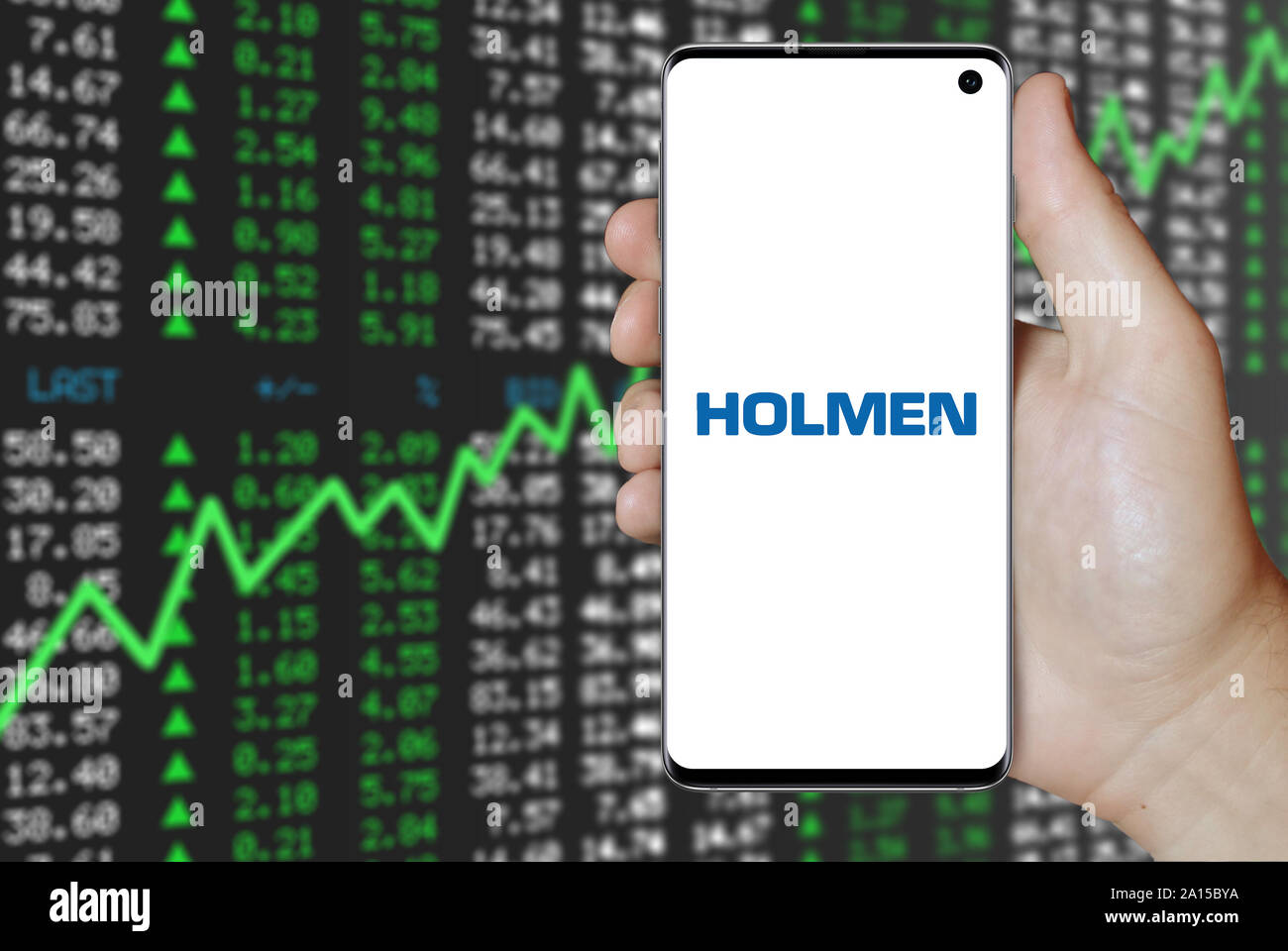 Un uomo possiede uno smartphone visualizzando il logo della società Holmen elencati su OMX di Stoccolma. Positivo del mercato azionario sfondo. Credito: PIXDUCE Foto Stock