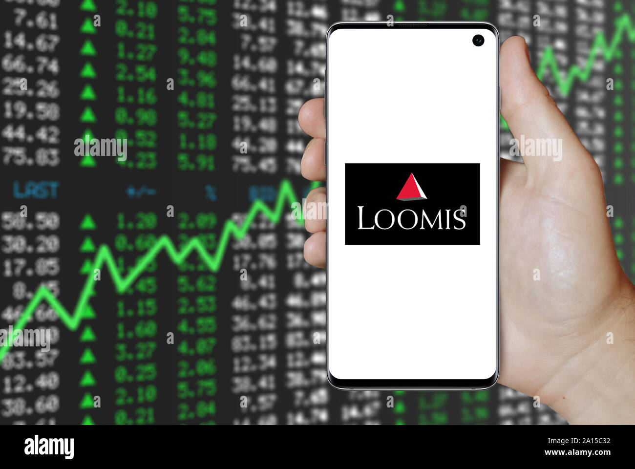 Un uomo possiede uno smartphone visualizzando il logo della società Loomis elencati su OMX di Stoccolma. Positivo del mercato azionario sfondo. Credito: PIXDUCE Foto Stock