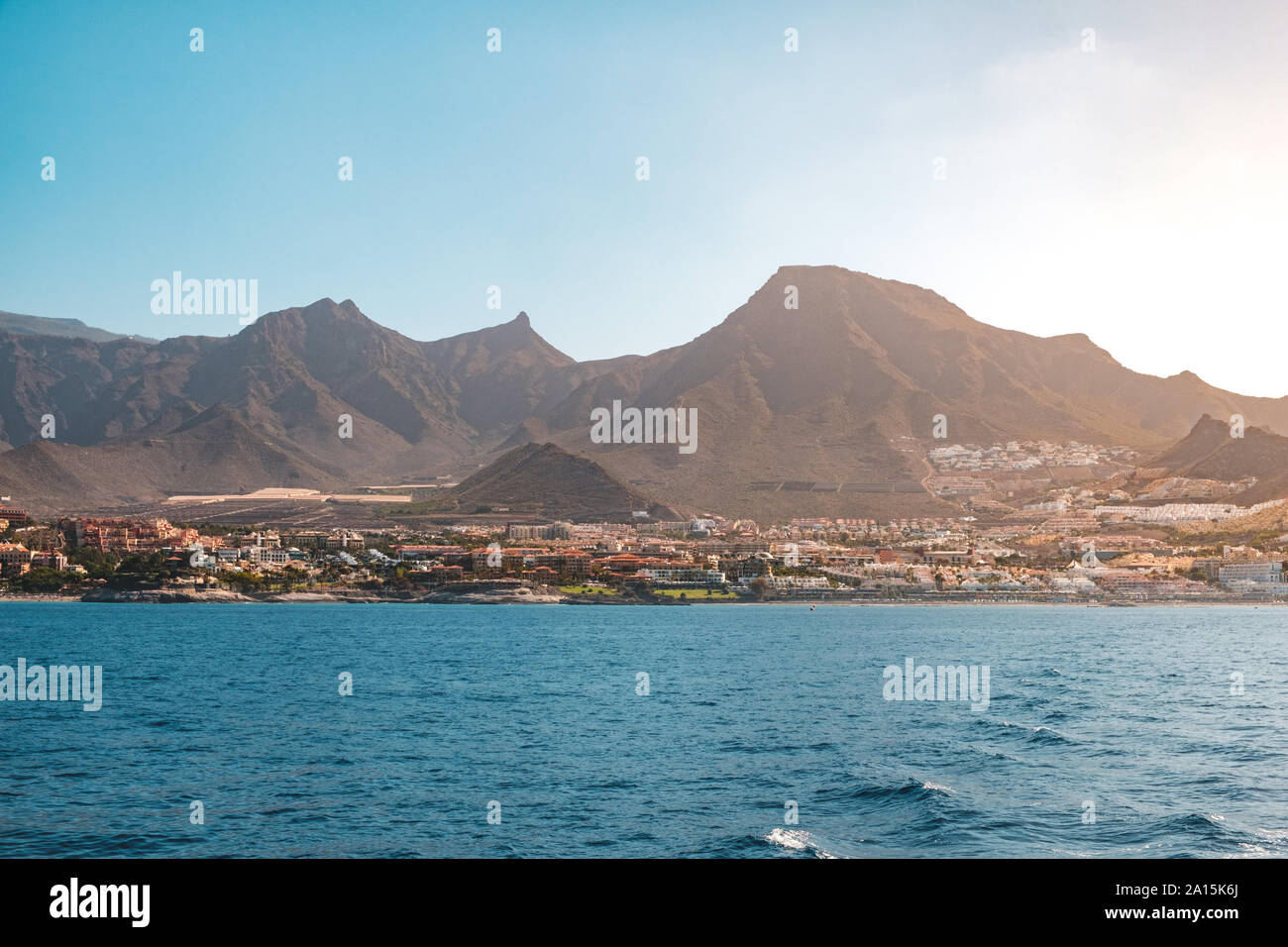 Vista oceano sulla riva con alberghi e città e panoramiche montagne sullo sfondo - costa di Tenerife - Foto Stock