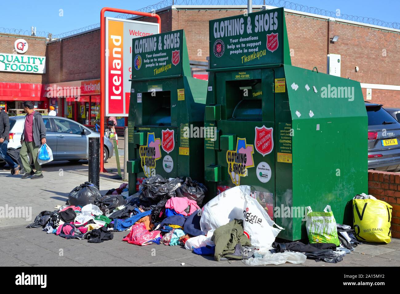 Traboccante Esercito della Salvezza vecchio abbigliamento e calzatura cassonetti sul marciapiede in South Road Southall West London Inghilterra England Regno Unito Foto Stock