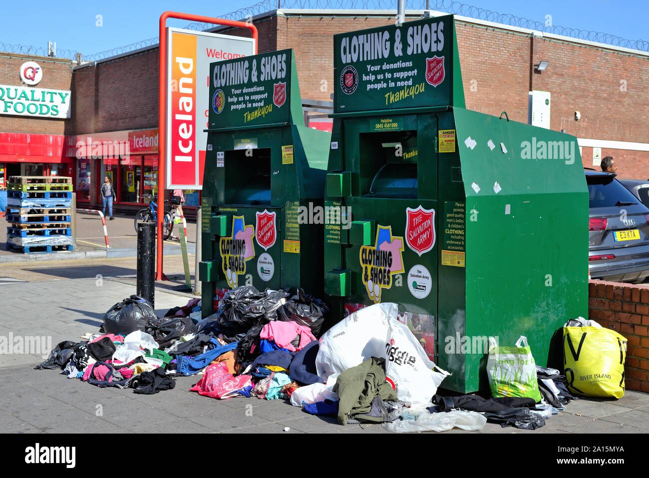 Traboccante Esercito della Salvezza vecchio abbigliamento e calzatura cassonetti sul marciapiede in South Road Southall West London Inghilterra England Regno Unito Foto Stock