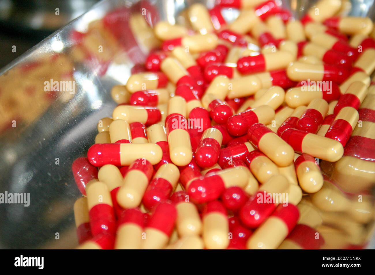 Medicina e salute. L'abuso di stupefacenti e delle tossicodipendenze, il dolore cronico, confusione di farmaci e materiale medico. Cascata di molti il bianco e il rosso pillole e capsule Foto Stock