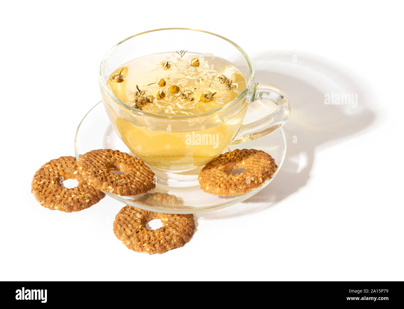 Tazza di erbe camomilla tè con biscotti, la luce del sole e ombra Foto Stock