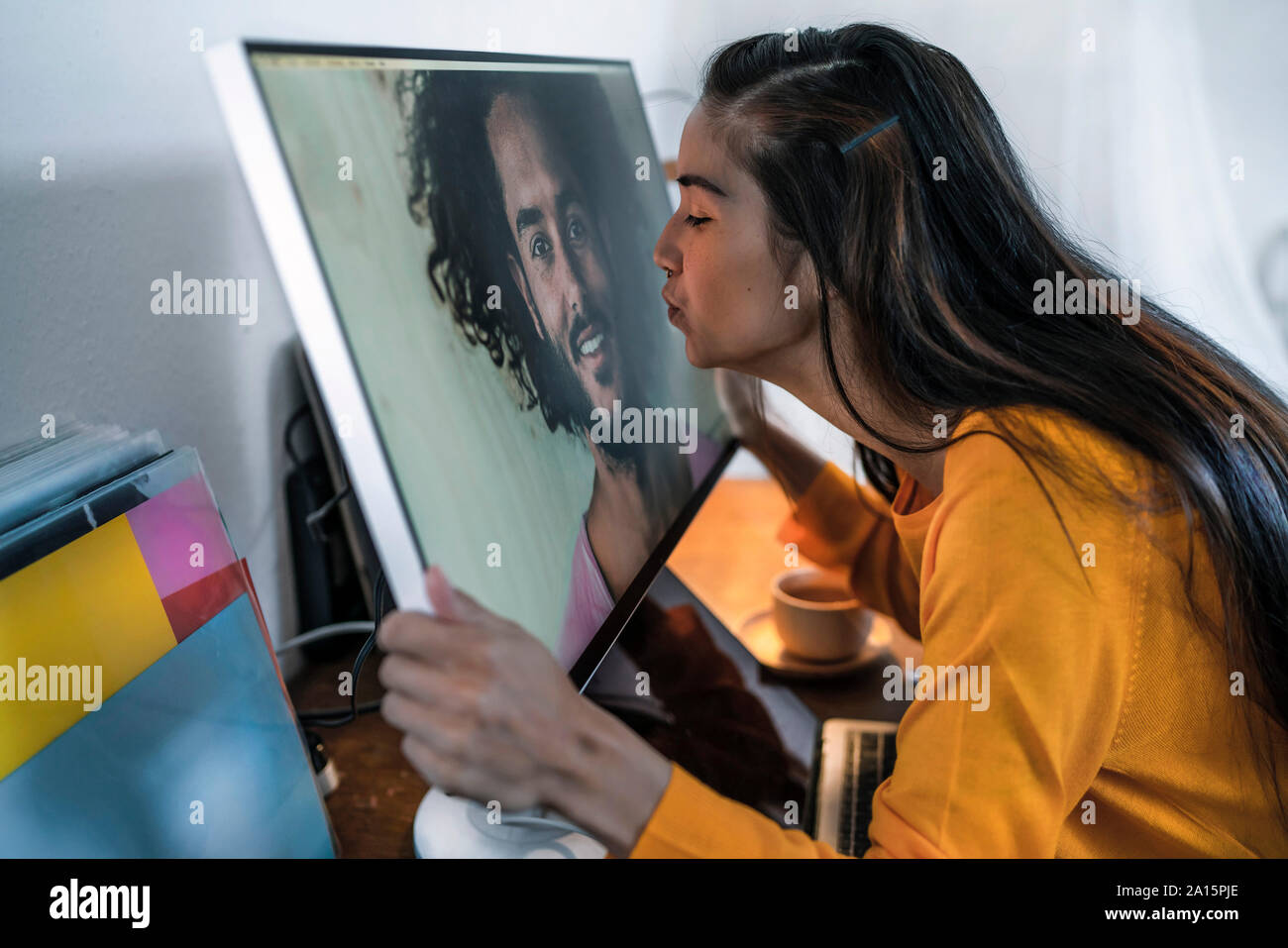 Giovane donna baciare uomo sullo schermo del computer Foto Stock