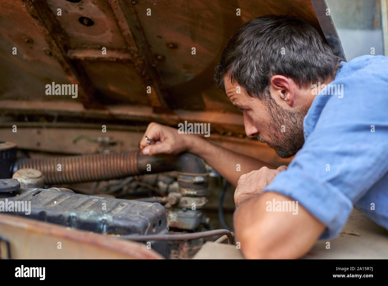 L'uomo con la vecchia auto avente una ripartizione Foto Stock