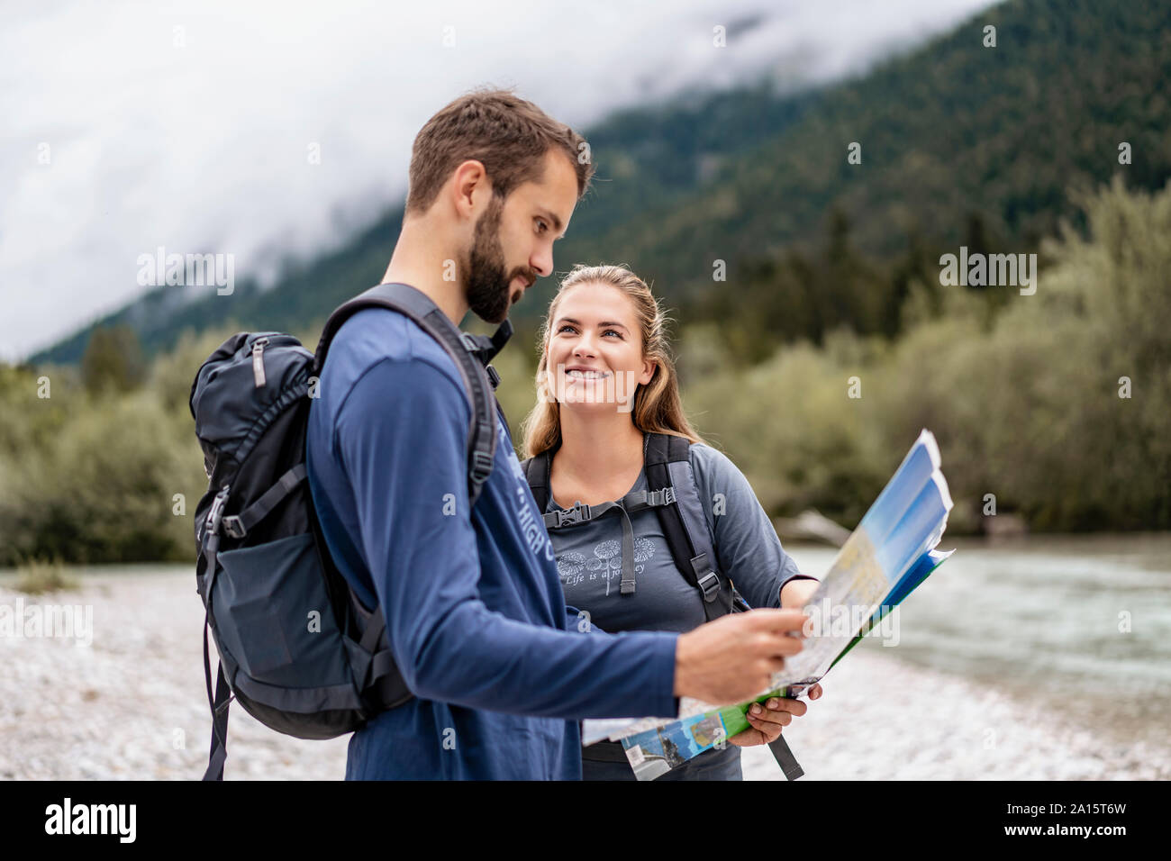 Una giovane coppia in un viaggio escursionistico mappa di lettura, Vorderriss, Baviera, Germania Foto Stock