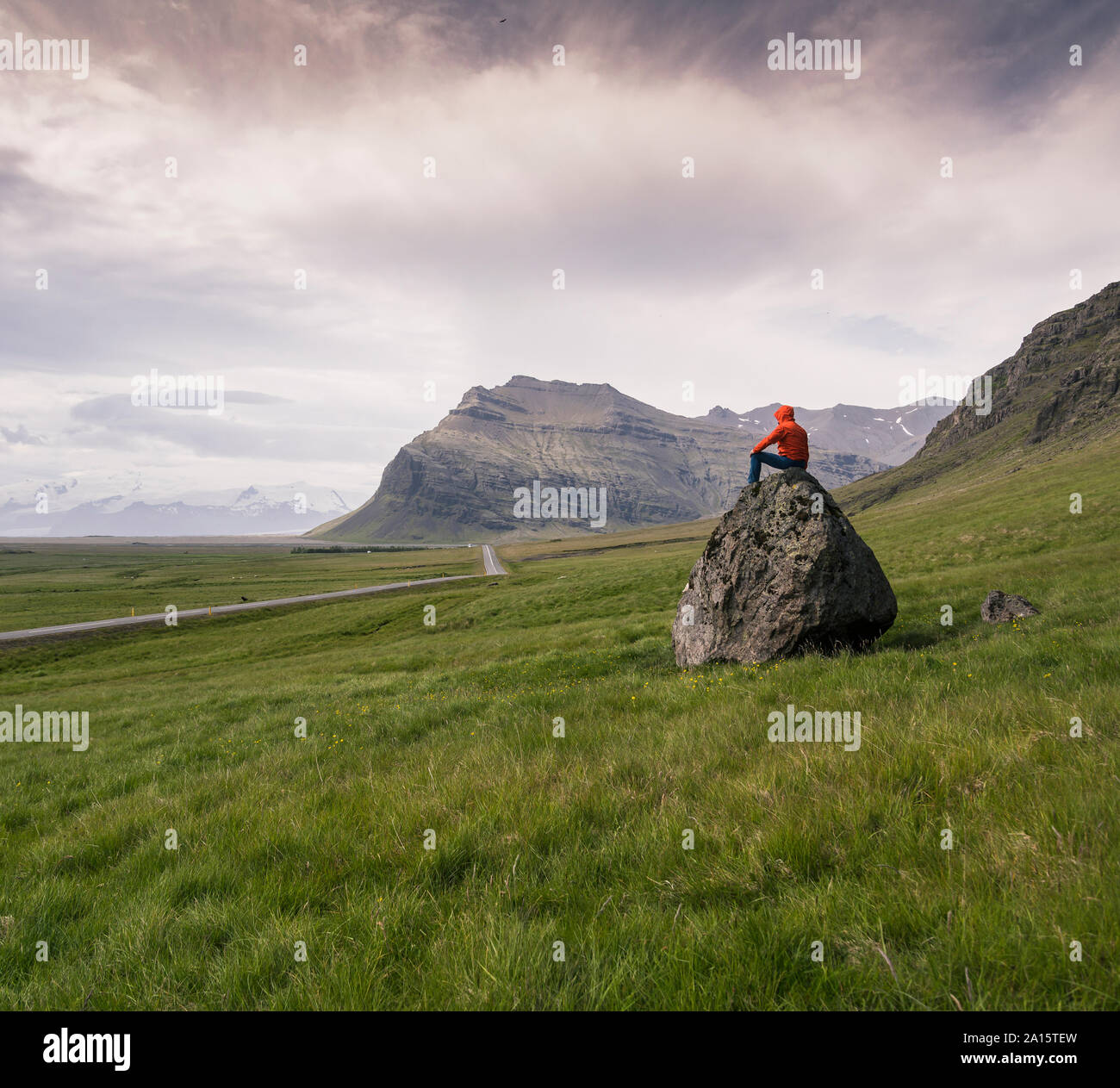 Uomo seduto sulla roccia in gthe Regione meridionale Islanda Foto Stock