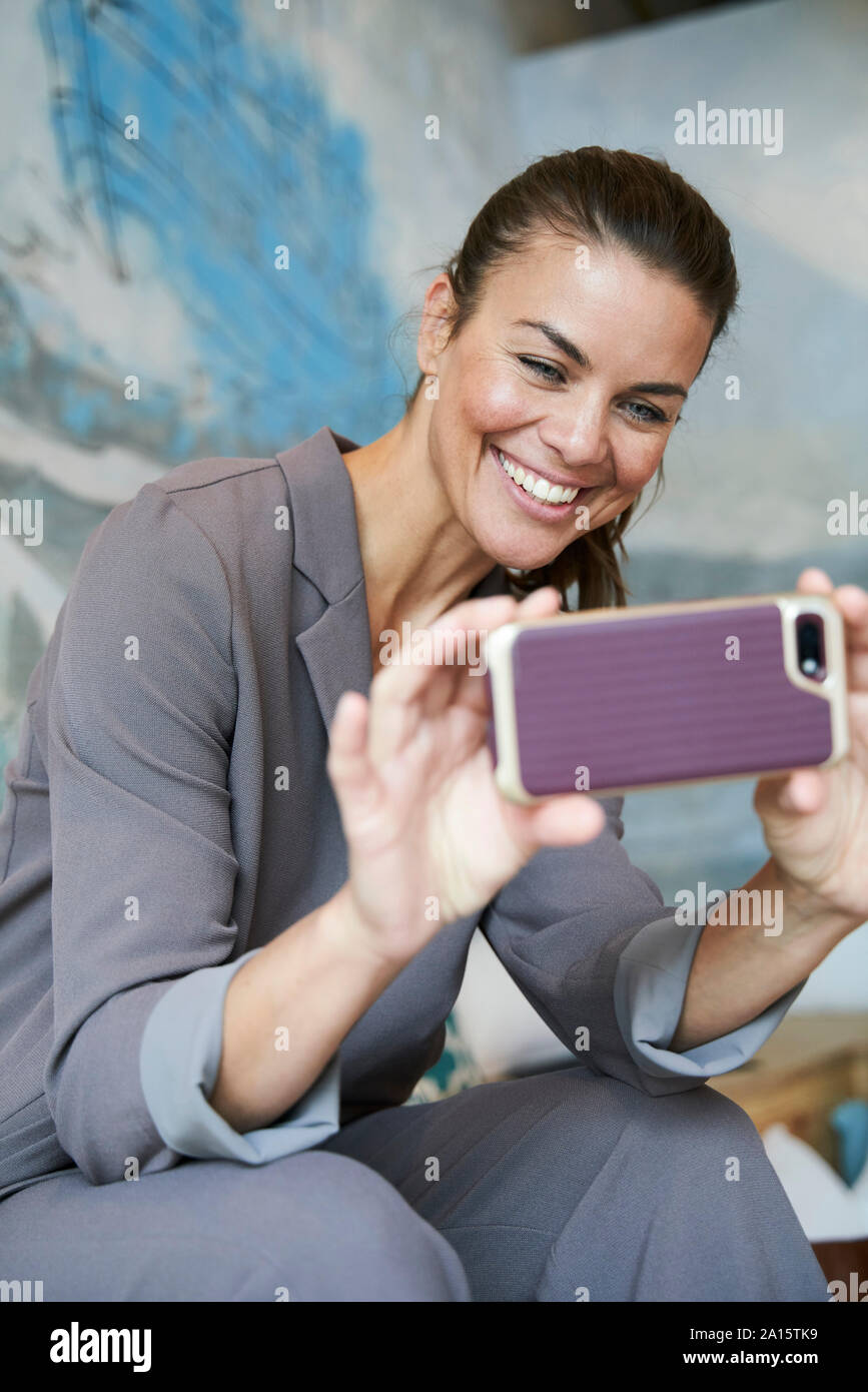 Felice imprenditrice utilizza lo smartphone Foto Stock