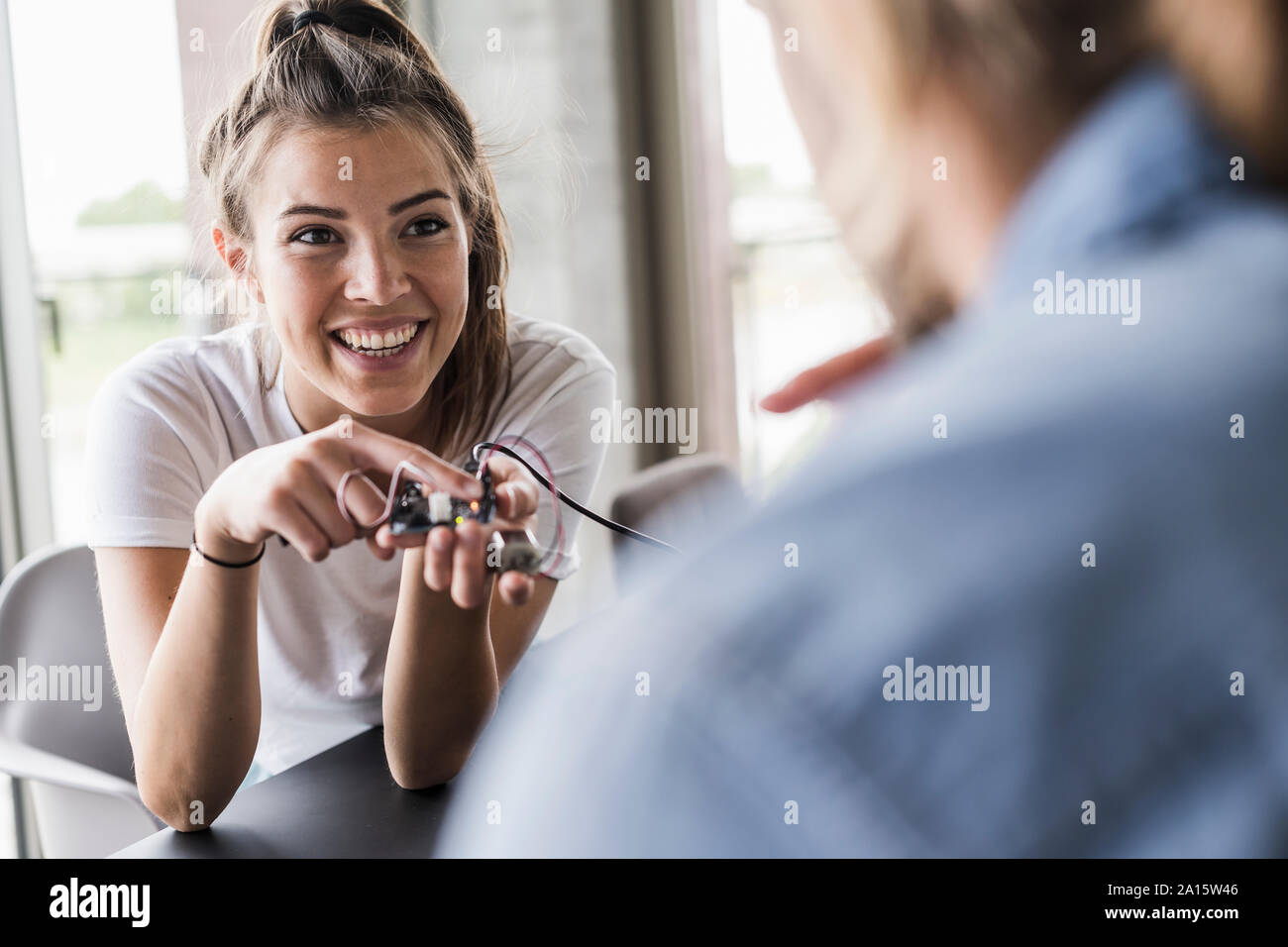 Felice giovane donna e uomo che lavora su apparecchiature per computer in ufficio Foto Stock
