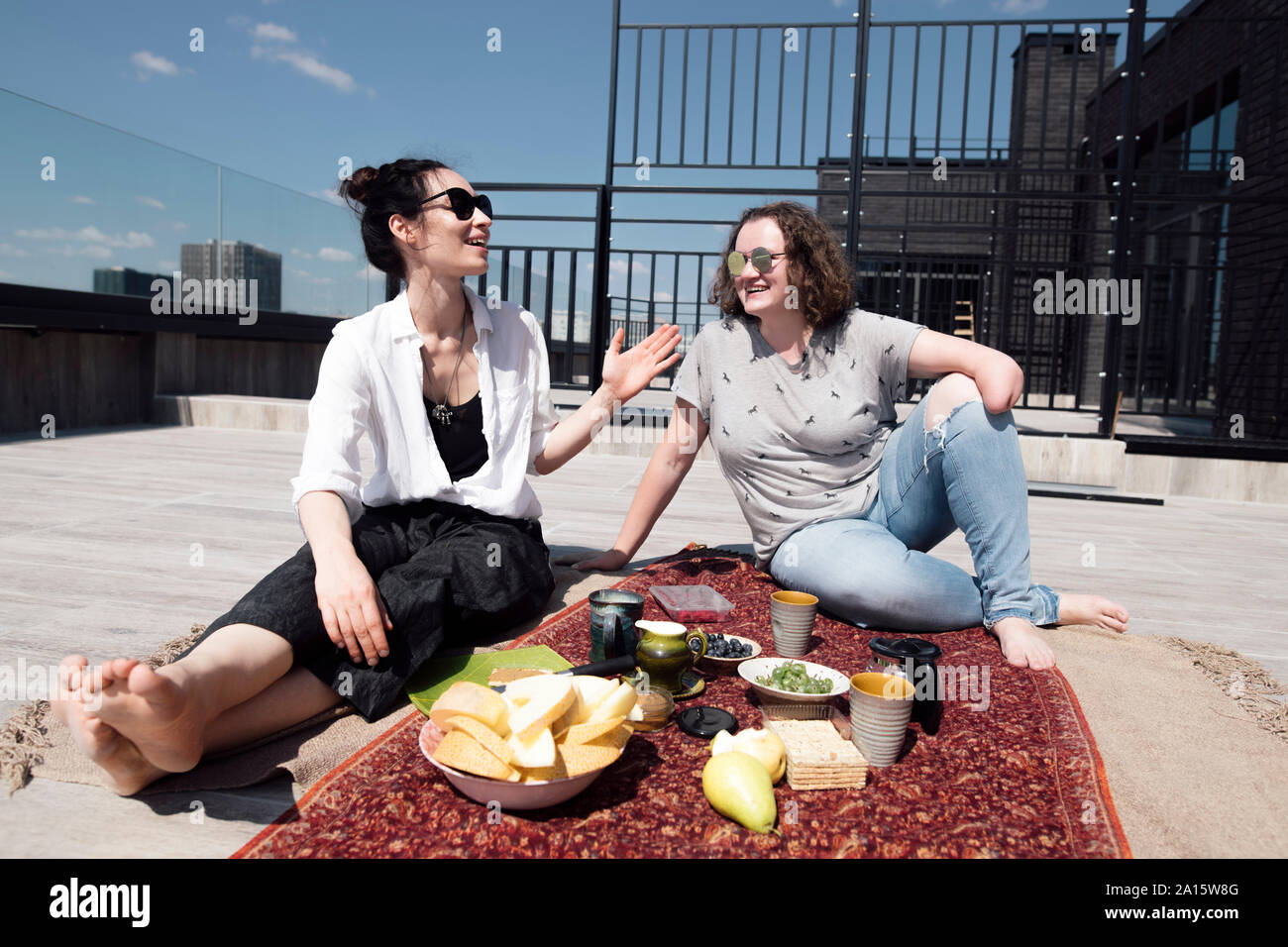 Donna con sotto-gomito amputazione con il suo amico avente un pasto sano sul tetto Foto Stock
