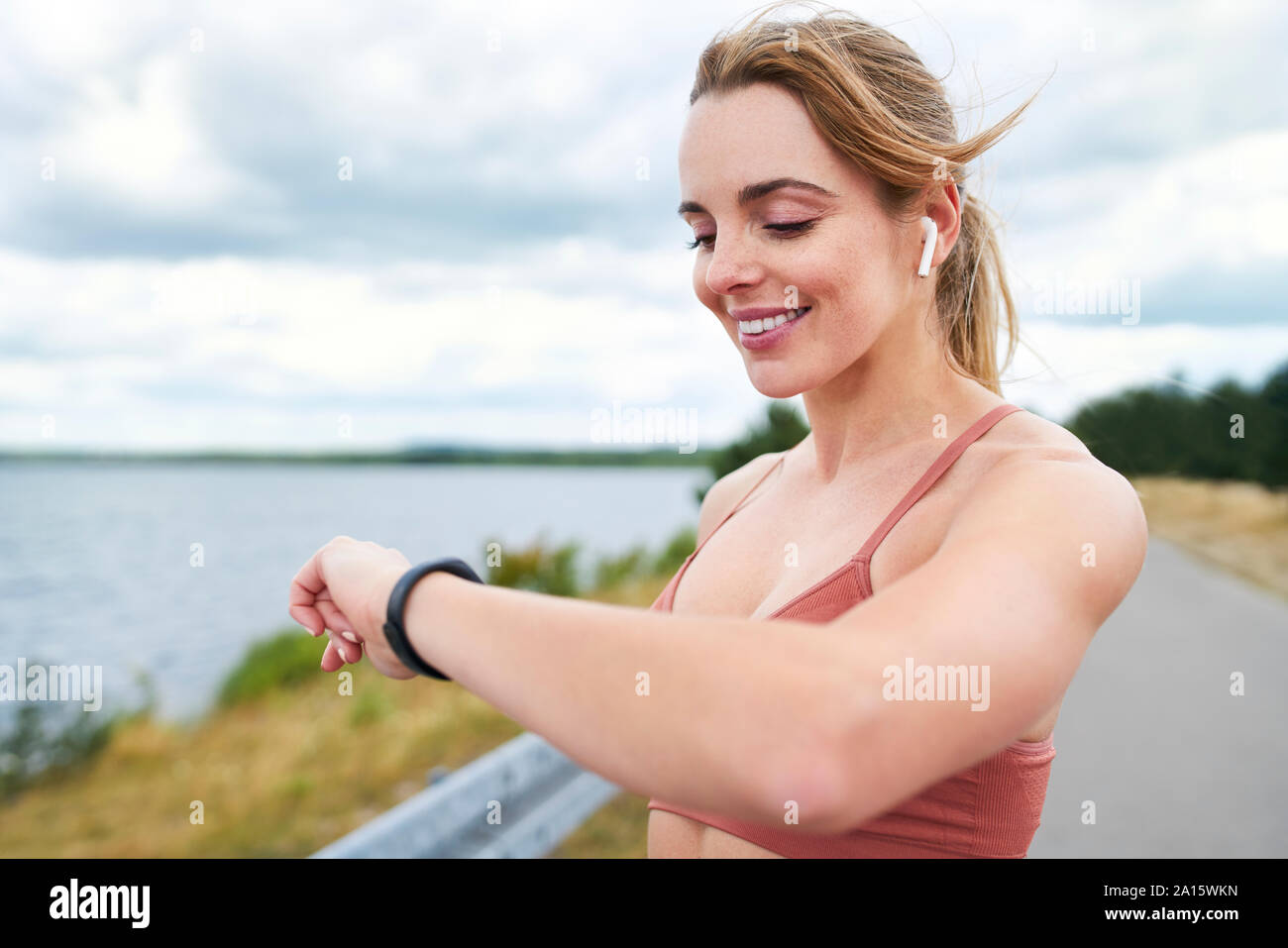 Ritratto di donna fit controllo smartwatch durante il jogging all'aperto la sessione Foto Stock