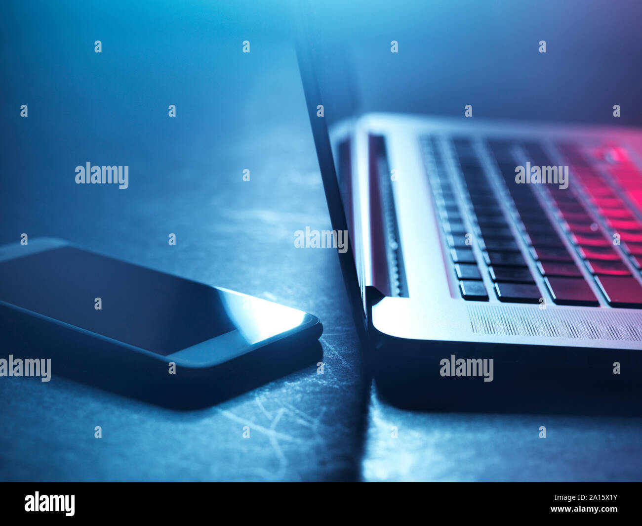 Laptop e smartphone a notte Foto Stock