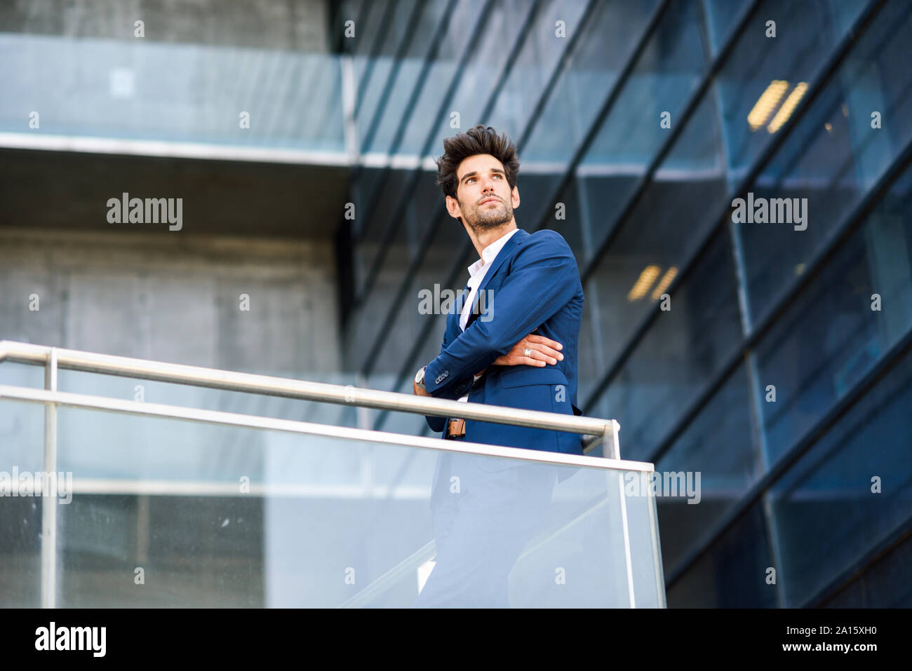 Imprenditore in piedi sul balcone di un edificio per uffici Foto Stock