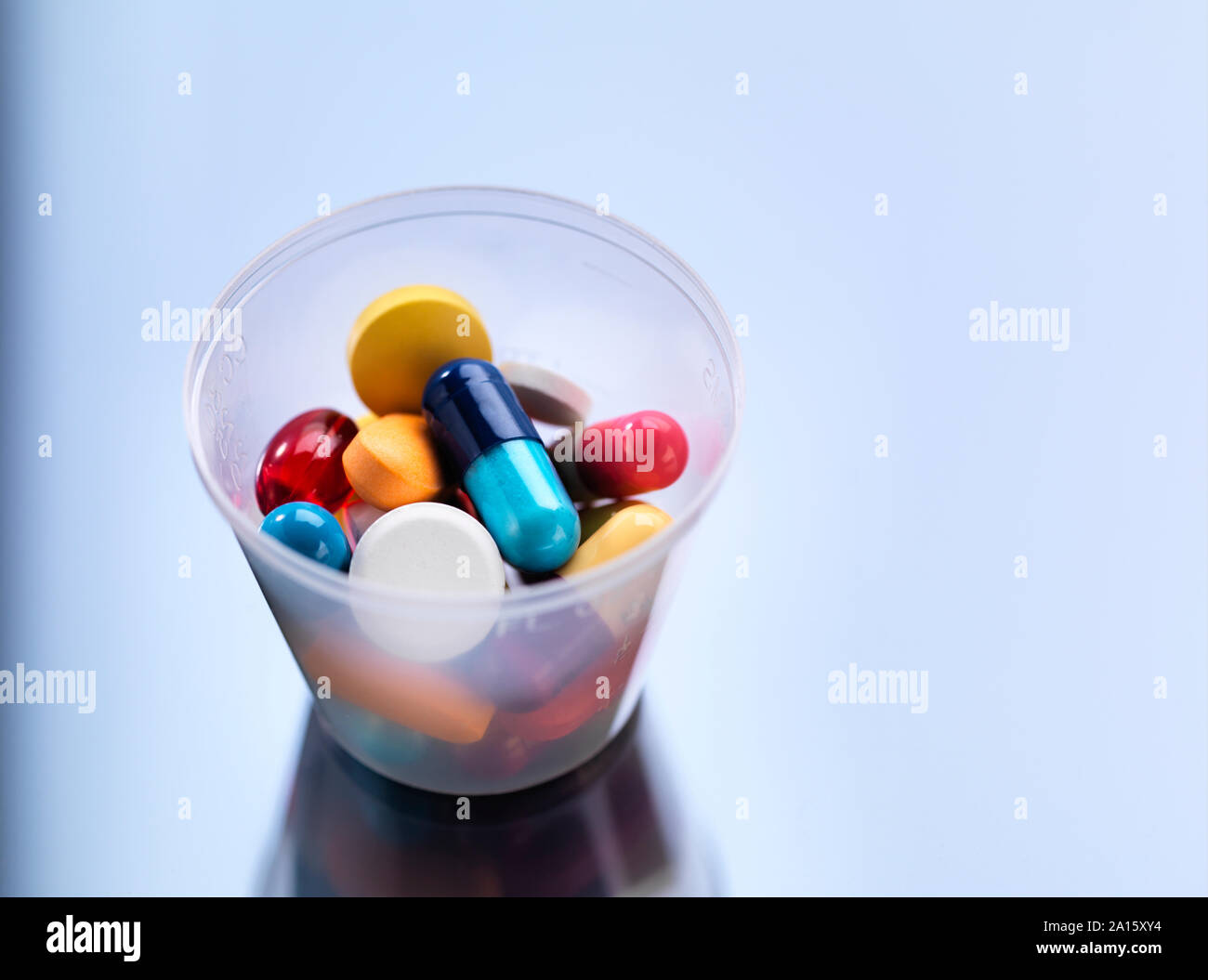 Medicina, pillole in una tazza di plastica Foto Stock