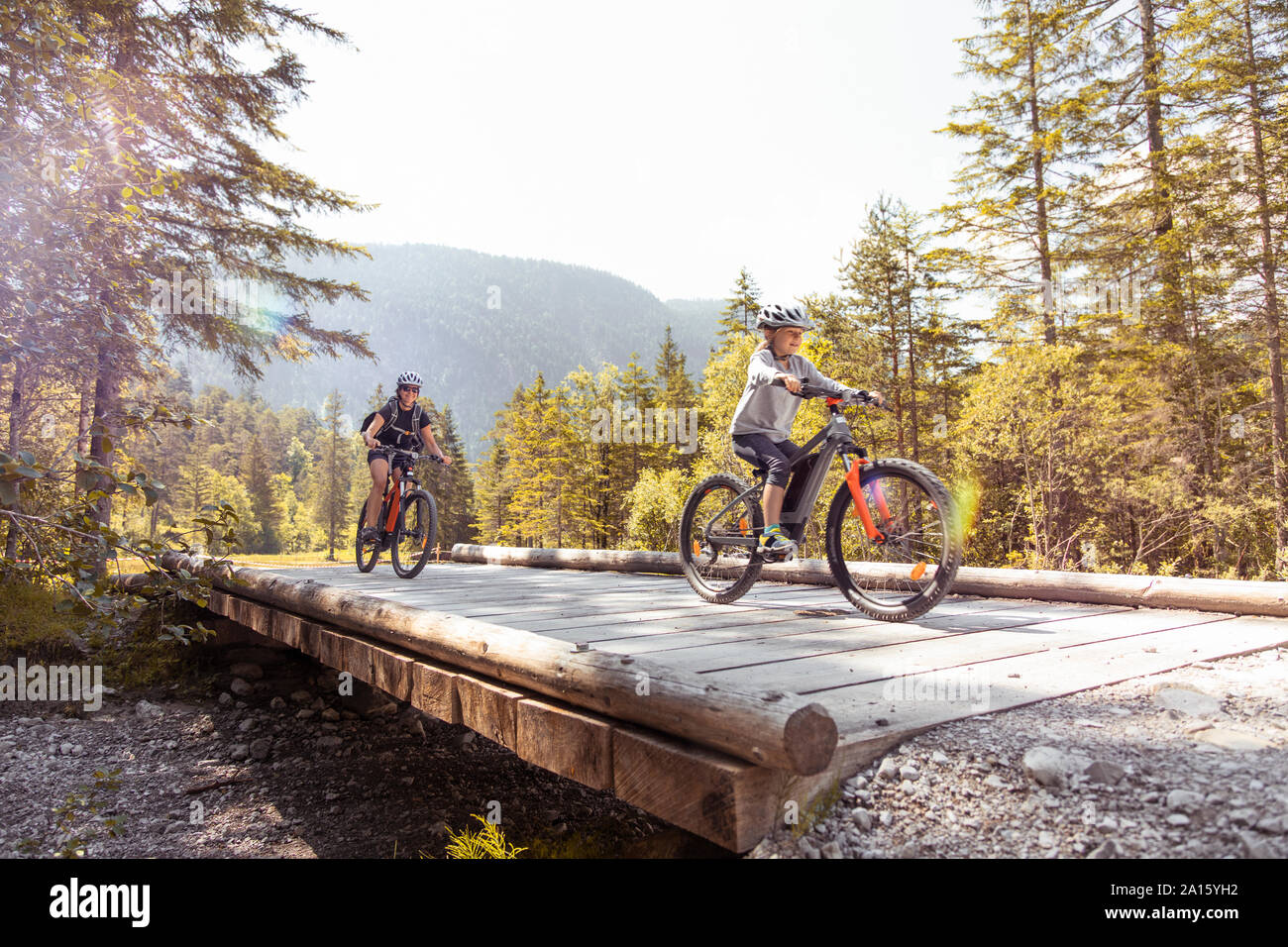 Madre e figlia in sella e-mountain bike in montagna Foto Stock