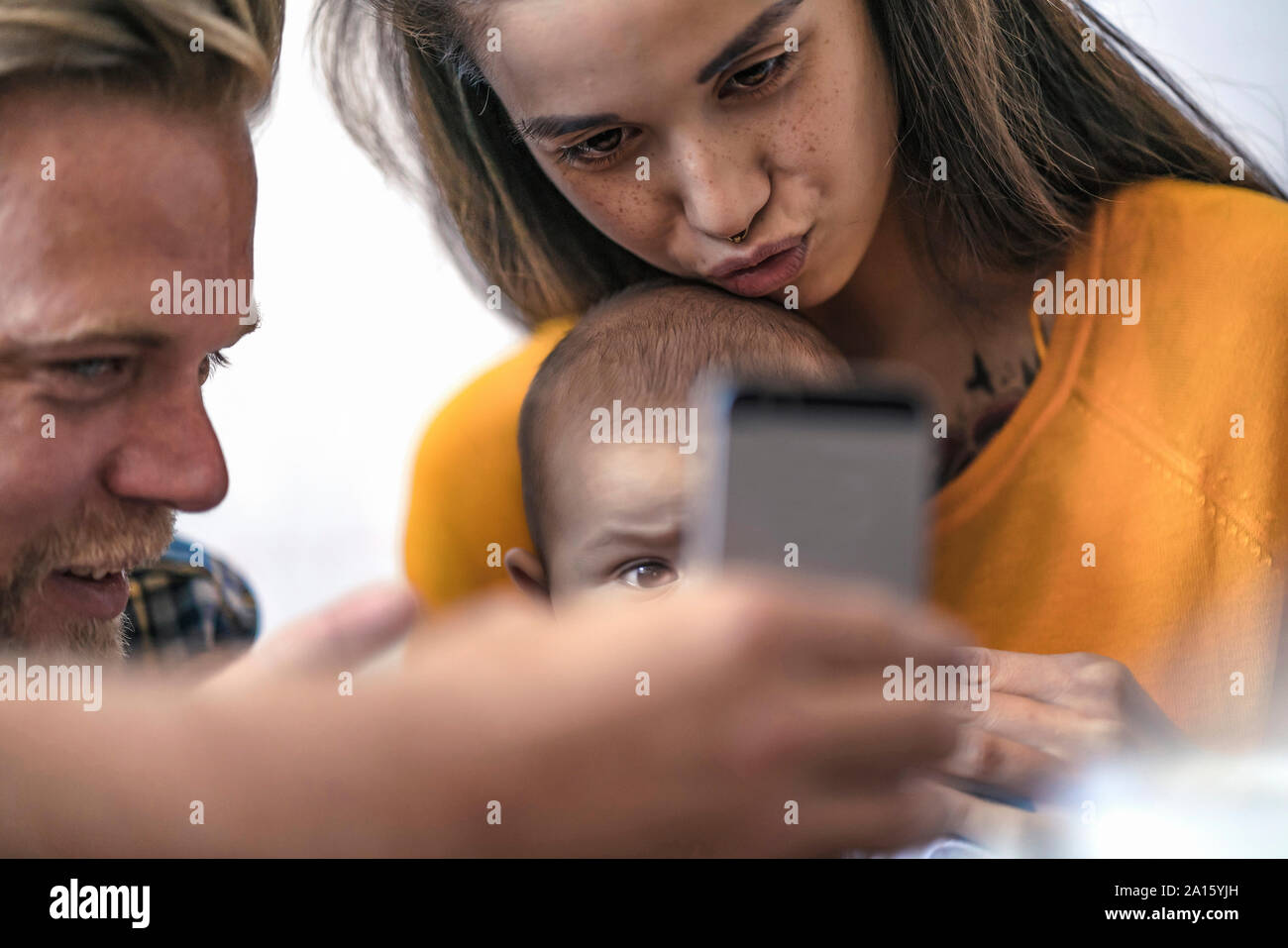 Famiglia con bambino con telefono cellulare Foto Stock