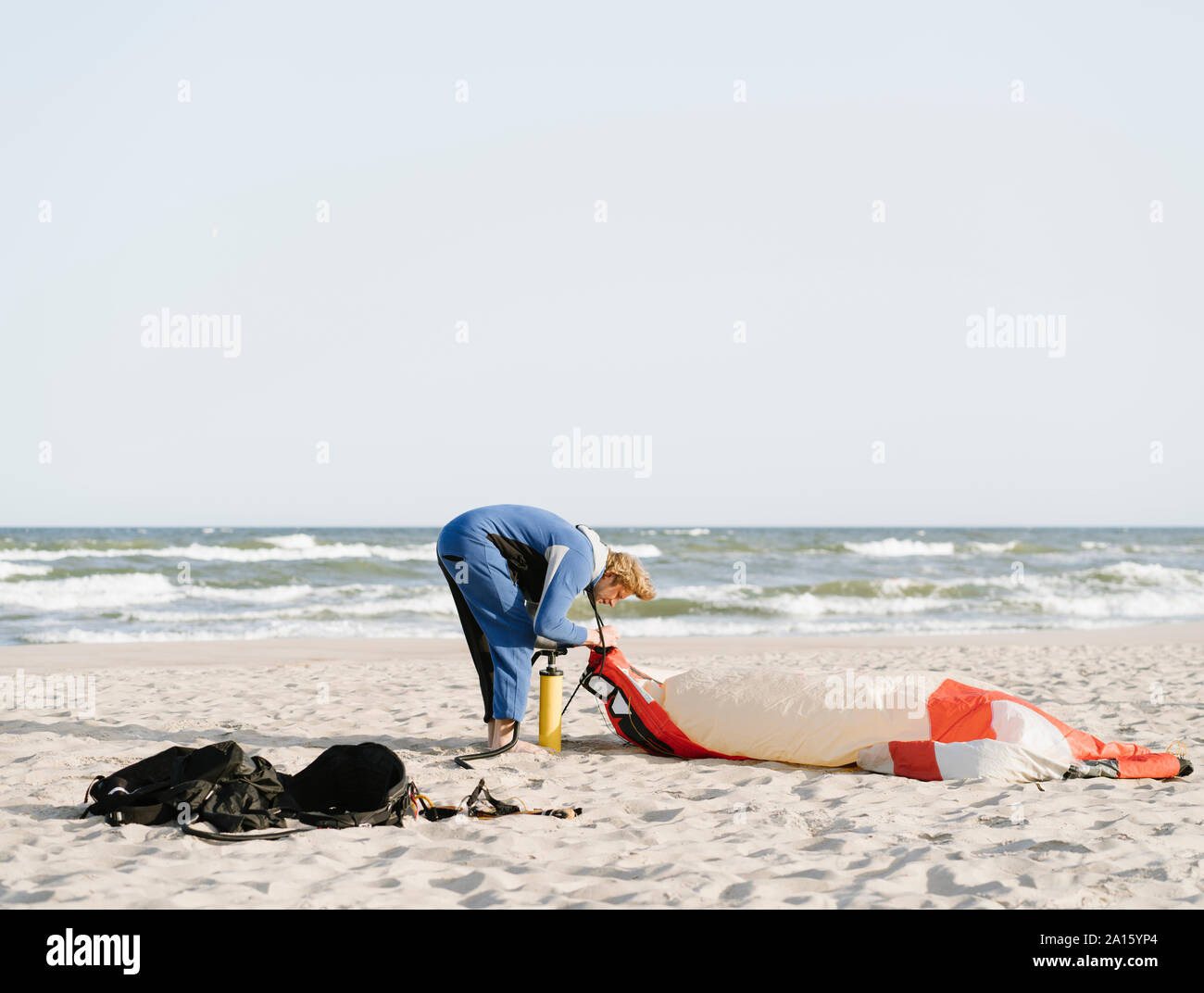 Surfista maschio preparare un aquilone su una spiaggia Foto Stock