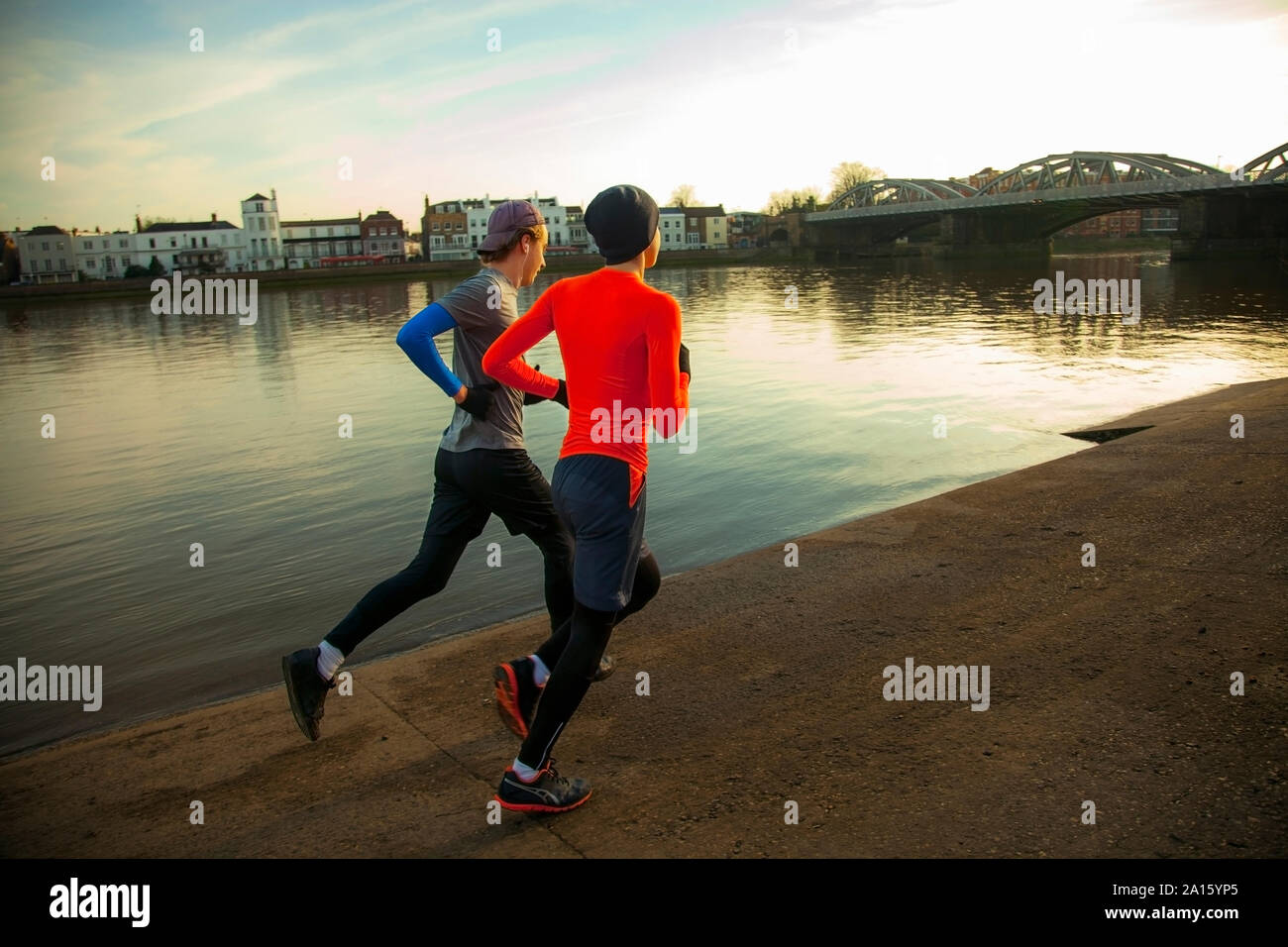 Due giovani uomini fare jogging lungo il fiume Tamigi, London, Regno Unito Foto Stock