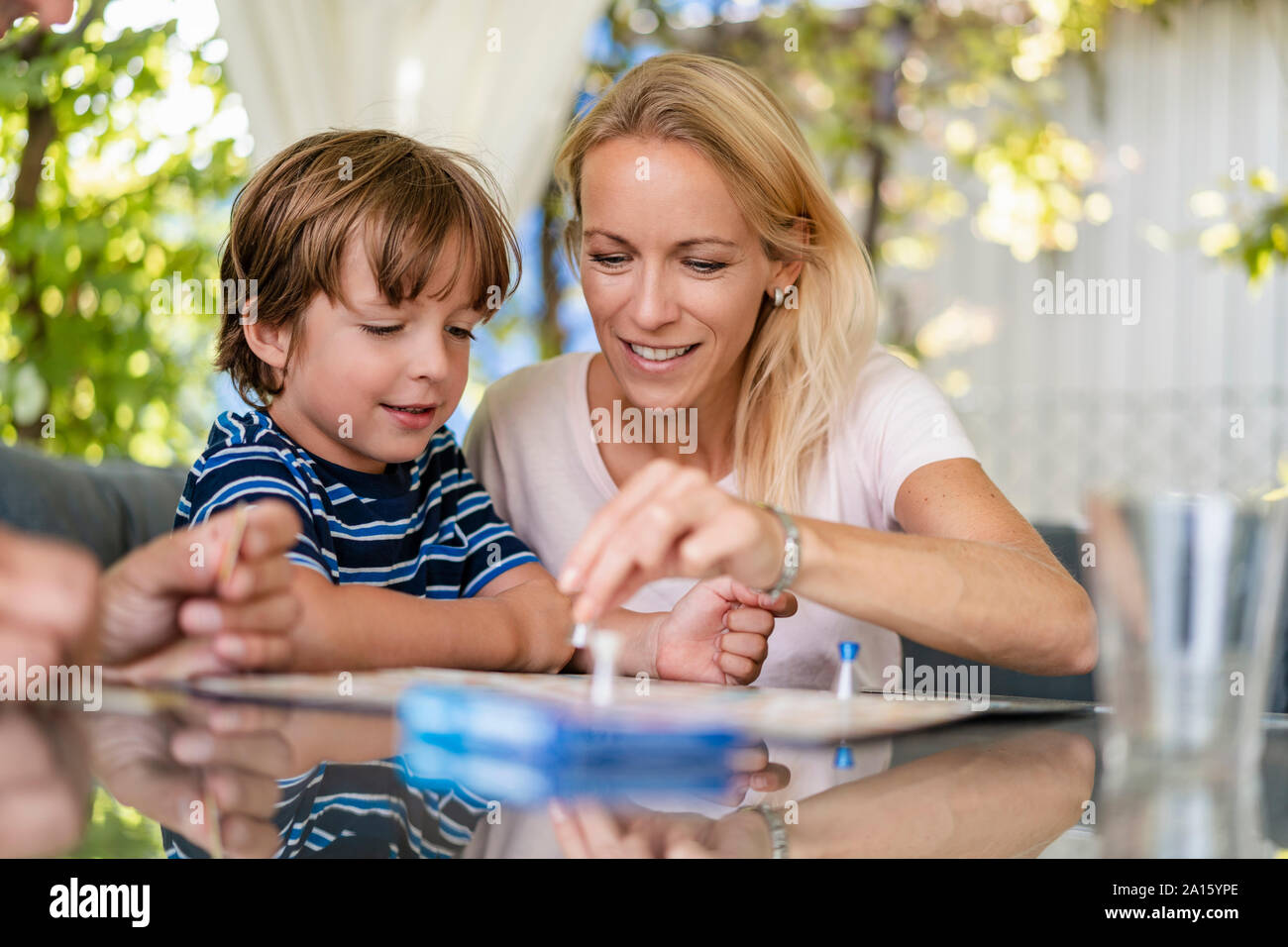 Madre e Figlio la riproduzione di un gioco da tavolo sulla terrazza Foto Stock