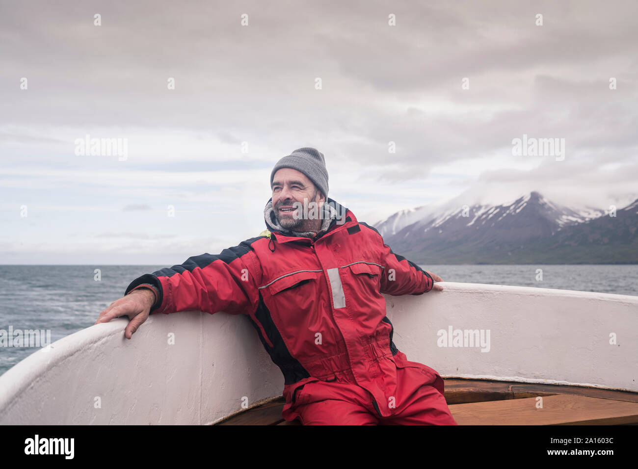 Uomo maturo guardando il mare, gite in barca sul fiordo Eyjafjordur, Islanda Foto Stock