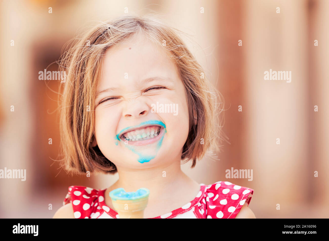 Una ragazza felice di mangiare un blue ice cream Foto Stock