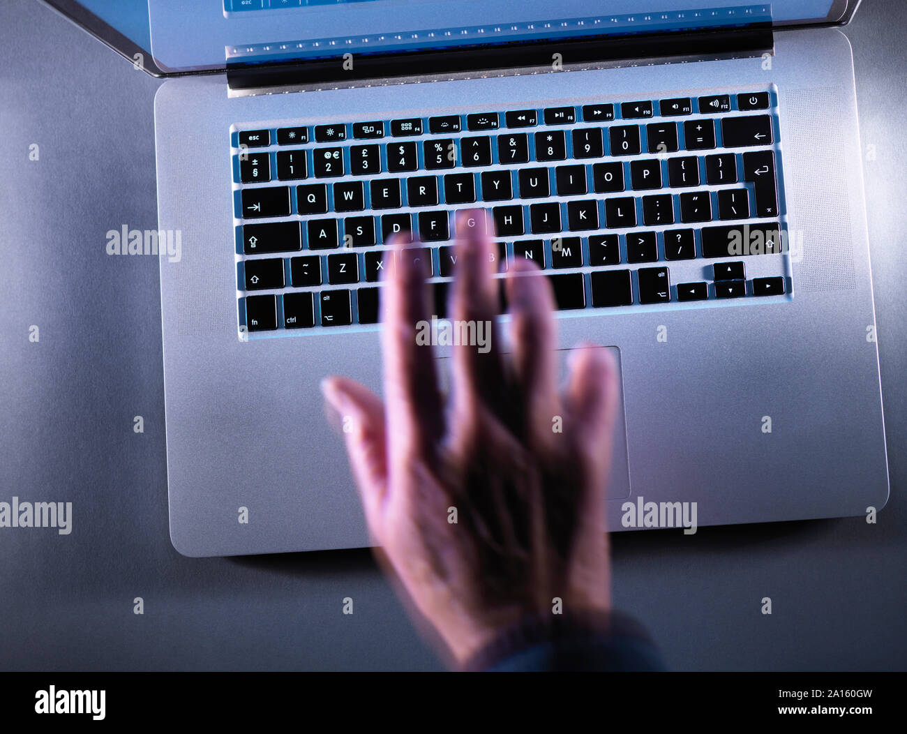 Cyber criminalità, muovendo la mano sfocata digitando su una tastiera Foto Stock
