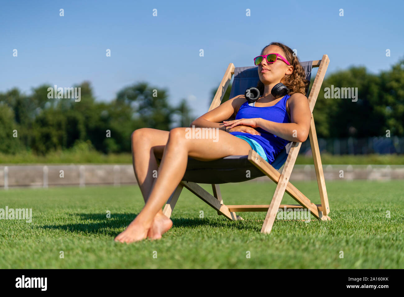 Giovane donna a prendere il sole sul prato Foto Stock