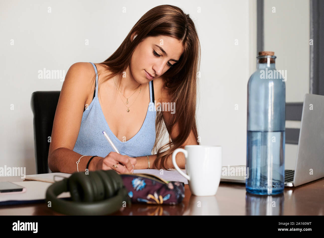 Studentessa che studiano a casa tramite computer portatile Foto Stock