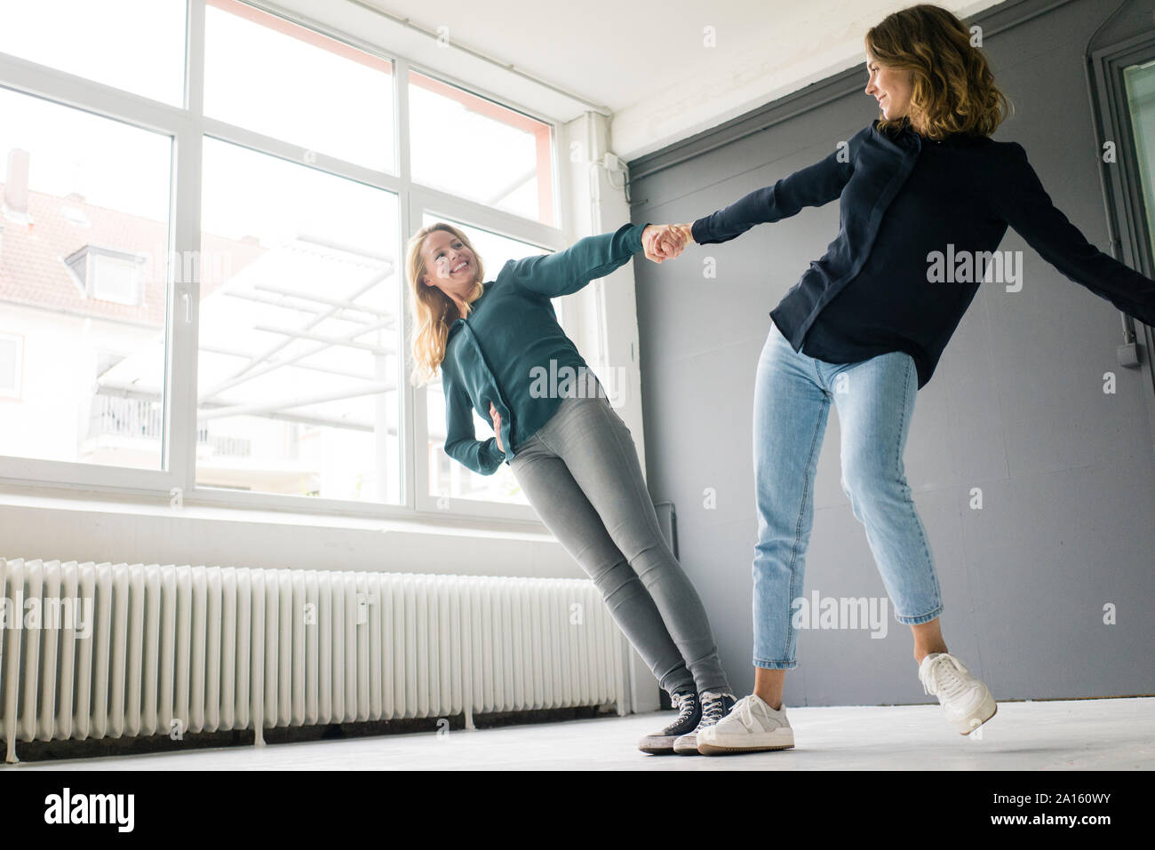 Due giovani donne a supporto di ogni altro scherzosamente Foto Stock