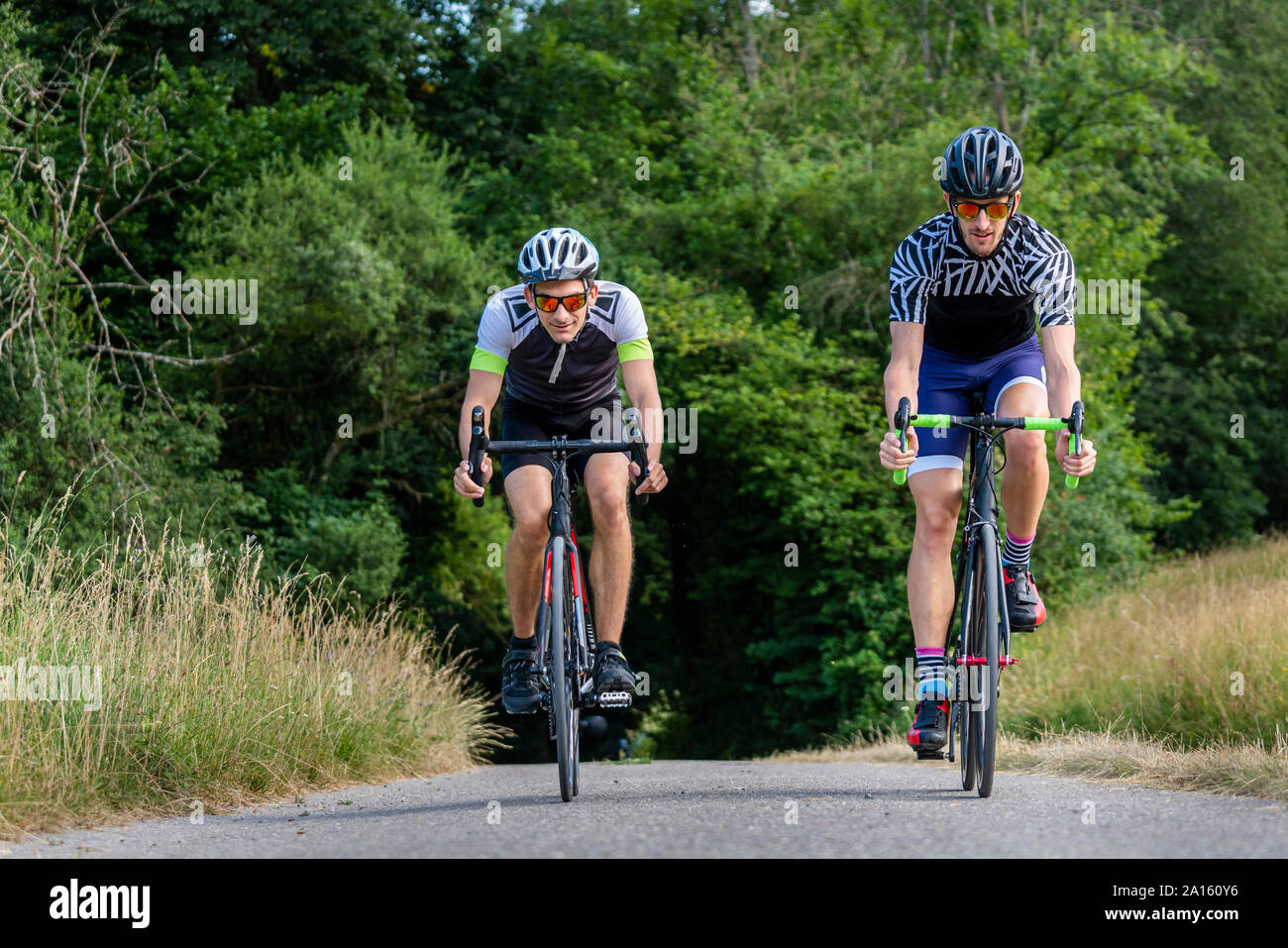 Triatleti equitazione bicicletta sulla strada di campagna, Germania Foto Stock