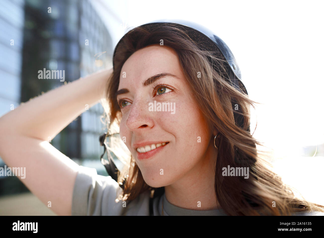 Donna con casco nero cercando lateralmente Foto Stock