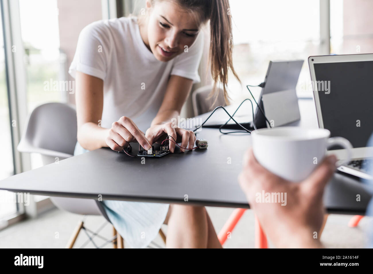 Giovane donna lavora su apparecchiature per computer in ufficio Foto Stock