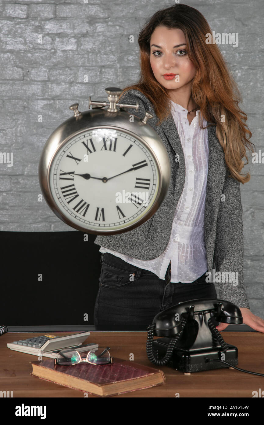 Business donna mostra un grande orologio Foto Stock