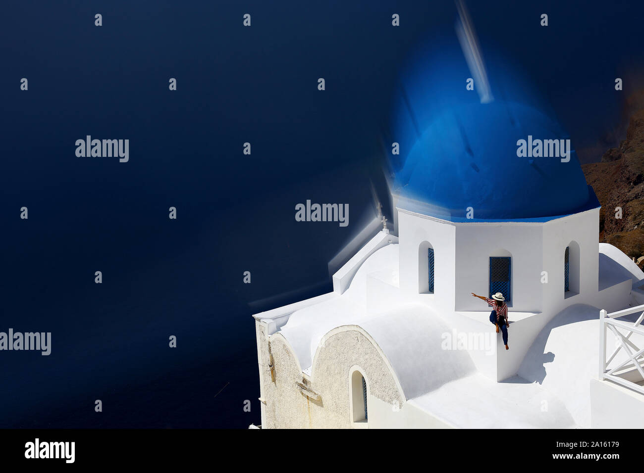 Donna sulla sommità di una cupola blu chiesa top, Santorini, Grecia Foto Stock
