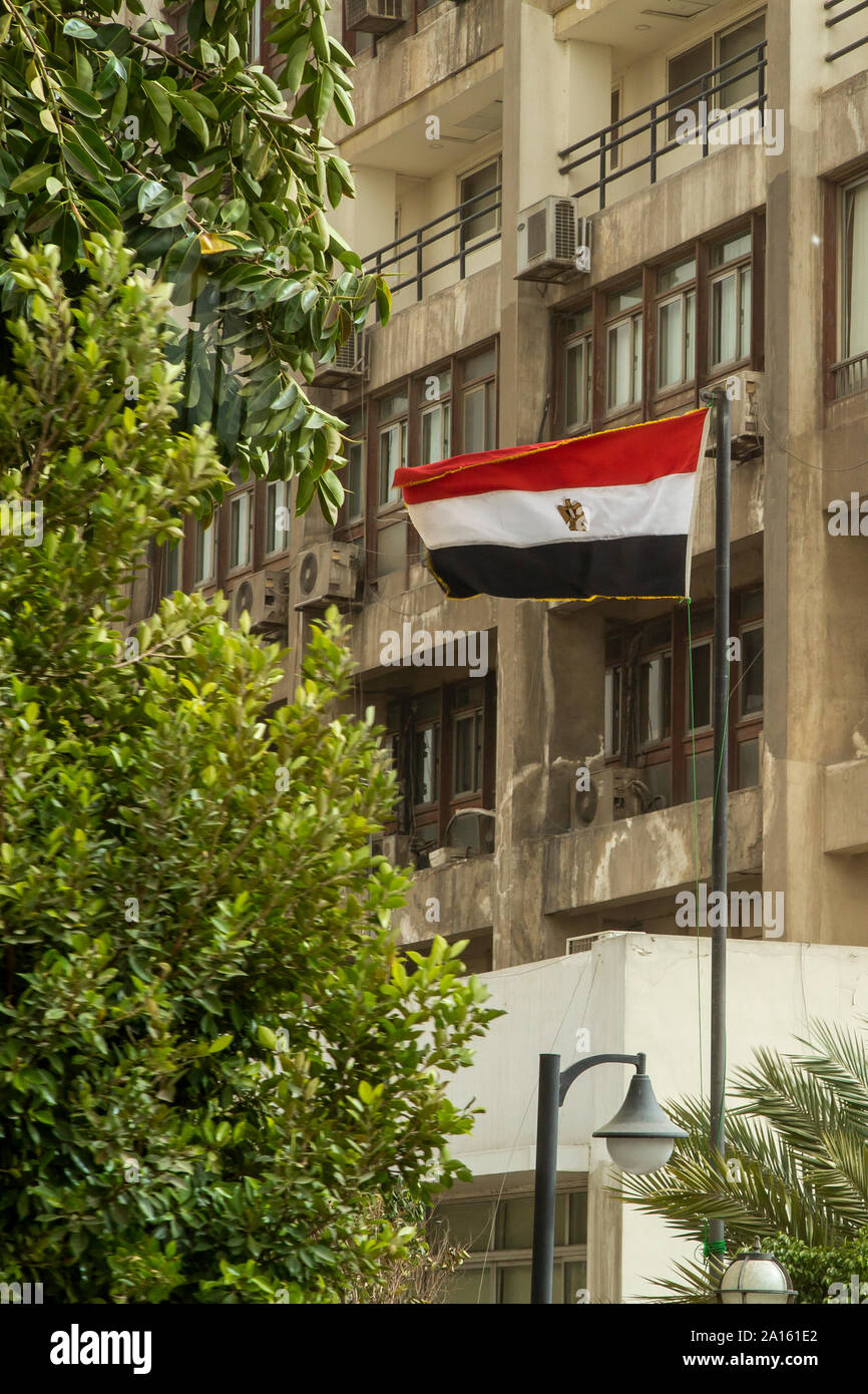 Basso angolo vista di bandiera egiziana contro la costruzione di Foto Stock