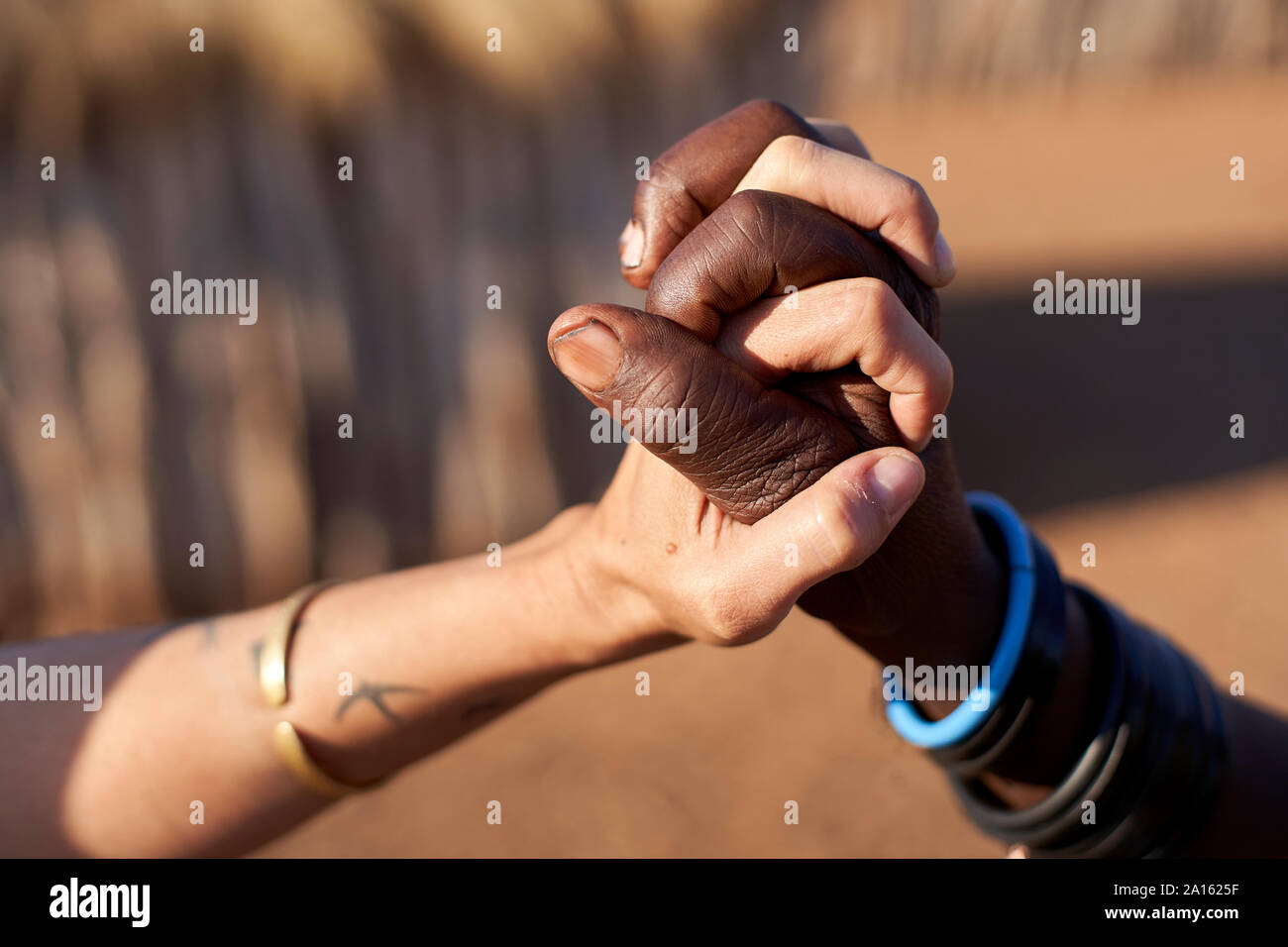 Tradizionale Muhacaona donna e donna bianca Holding Hands, Oncocua, Angola Foto Stock